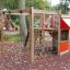 Kleiner Dschungel Klettergerüst mit Rutsche und Spielhaus im Park.