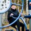 Frau benutzt Outdoor-Fitnessgerät im Herbstpark.