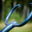 Blaue Klettergerüst-Griffe im Freien mit unscharfem Waldhintergrund.