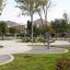 Spielplatz mit Outdoor-Fitnessgeräten und gepflegten Wegen in einem Park.