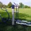 Outdoor-Fitnessgerät auf einer grünen Wiese in einem öffentlichen Park.
