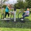 Senioren nutzen Outdoor-Fitnessgeräte im Park.