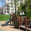 Barrierefreier Spielplatz von Gamma mit Rutsche und Klettergerüst in einem Park.