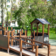 Barrierefreies Spielgerät Gamma auf einem Spielplatz, umgeben von Grünanlagen.