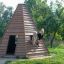 Kinder spielen in einem Wigwam Spielhaus im Garten.