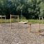 Hürde Holz-Klettergerüst für Kinder auf einem Kiespielplatz.
