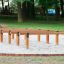 Holzspielplatzgerät Hip Hop mit Balancierbalken auf Sandboden im Park