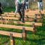 Kinder trainieren Balance auf einem Holzparcours im Freien.