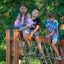 Schmetterling Kletternetz Groß auf einem Spielplatz mit drei Kindern spielend.