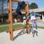 Kinder klettern auf einer großen Holzleiter auf einem Spielplatz.