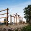 Großes Holzspielgerüst im Außenbereich auf Kiesboden.
