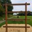 Große Leiter auf einem Spielplatz mit Sand und Gras im Hintergrund.