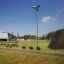 Outdoor-Spielplatz mit Kletterrampe und Hindernisparcours in einer Parkumgebung.