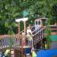 Kinder spielen auf König Spielschiff mit Spiralrutsche im Park
