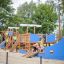 König Spielschiff mit Spiralrutsche und Kindern beim Spielen auf einem Spielplatz