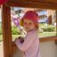Kind spielt auf Spielkombination mit Spielturm und Rutsche auf Spielplatz.