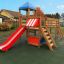 Spielkombination mit Spielturm, Rutsche und Kletterelementen für Kinder auf einem Spielplatz.