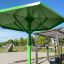 Grüne Umbrela Sonnenschutzkonstruktion auf einem Spielplatz.