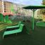 Grüner Umbrela Sonnenschirm und Rutsche auf einem Kinderspielplatz.