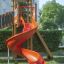 Twister Spielanlage mit Rutsche in orangener Farbe auf einem Kinderspielplatz.