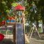 Kinderspielplatz mit Rutsche, Schaukel und Kletterturm im Freien.