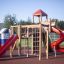Kinderspielplatz mit Rutsche und Klettergerüst im Freien.