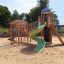 Kinderspielplatz mit Twister Spielanlage und Rutsche in einem Sandbereich.