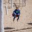 Kind auf Schaukelrahmen aus Robinienholz auf Spielplatz