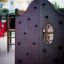 Spielturm mit Kletterelementen und Rutsche auf einem Spielplatz.