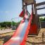 Bonn Spielanlage mit roter Rutsche, Spielturm und Klettergerüst auf einem Spielplatz.