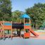 Tarzan Spielanlage mit Spielturm, Tunnel und Rutsche auf einem Kinderspielplatz.