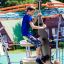 Junge klettert auf einem Andromeda Klettergerüst mit Kletterwand auf einem Spielplatz.