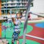 Junge klettert auf Andromeda Klettergerüst mit Kletterwand auf einem Spielplatz.