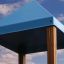 Blauer Dachteil der Spielanlage Drei Spieltürme Festung mit Rutsche vor blauem Himmel.