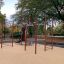 Spielplatzgerät New Age Fit MEDIUM mit Kletterringen und Rutschen auf einem öffentlichen Spielplatz.