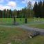 Outdoor-Fitnessgeräte New Age Fit in einem Park mit grüner und grauer Ausrüstung.