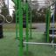 Grüner Outdoor-Fitnessparcours New Age Fit mit verschiedenen Trainingsstationen.