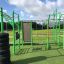 Grüner Outdoor-Fitnesspark New Age Fit mit Kletterwand und Hangelringen.