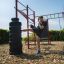 Mann trainiert Beinkraft auf einem Outdoor-Fitnessgerät im Park.