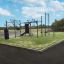 Outdoor-Fitnessgerät New Age Fit auf grünem Untergrund mit Reifen und Basketballkorb.