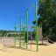 Grünes Klettergerüst für Kinder auf einem Spielplatz.
