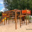 Kinderspielplatz mit Rutsche, Kletternetzen und Spieltürmen in lebendigen Farben.