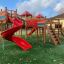 Weltraumstation mit Spieltürmen und Spiralrutsche auf Spielplatz, farbenfrohes Spielgerät für Kinder