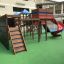 Kinder-Spielplatz mit Weltraumstation, Spieltürmen und Spiralrutsche auf grünem Boden.