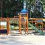 Weltraumstation mit Spieltürme und Spiralrutsche auf einem Spielplatz im Freien.