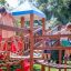Kinder spielen auf einer Weltraumstation mit Spieltürmen und Spiralrutsche im Garten.