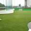 Kunstrasen-Sportplatz mit Fußballtoren und umgebender Netzbarriere.