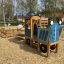 Spielplatz Traktor Spielhaus mit Anhänger auf Holzhackschnitzeln.