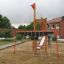 Mast Klettergerüst auf einem Spielplatz mit Rutsche und Kletternetz.