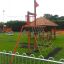 Kinder Kletterspielplatz Mast Klettergerüst mit Rutsche und Kletternetz auf grünem Gras.